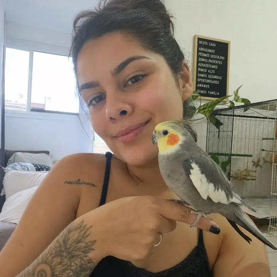 Tutora com sua calopsita no dedo